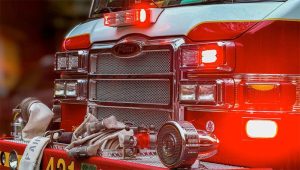Detailed view of a fire truck with flashing red lights, emphasizing its role in emergency services.